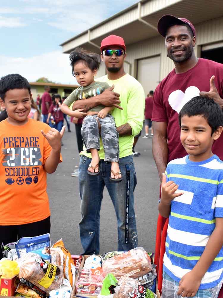 Community members in Hawaii receiving assorted bread and produce from the 'Ohana Produce Plus program, enhancing food access for families.