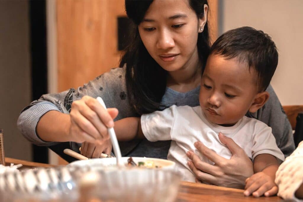 A mother enjoys a meal with her young son.